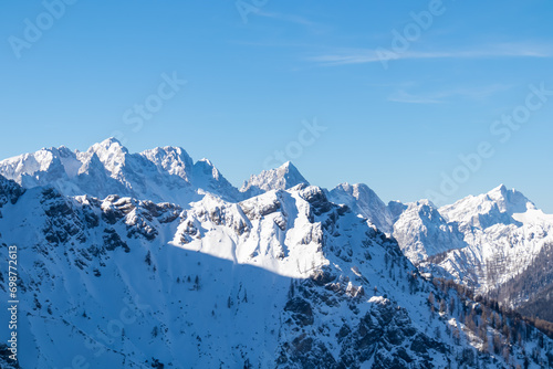 Scenic view from Ferlacher Spitze on snow covered mountains Mangart, Mittagskogel and Spik in Karawanks, Carinthia, Austria. Winter wonderland in Austrian Alps, Julian Alps and Triglav National Park