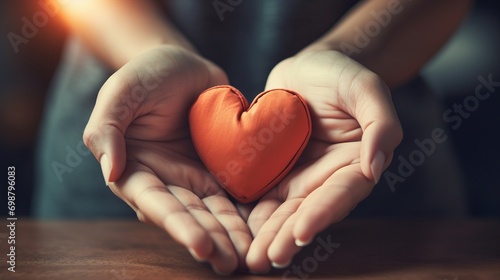 Female hands holding a red heart on a wooden table in a cafe. Generative AI