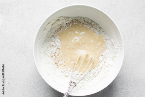 vanilla almond muffins batter in a white mixing bowl, almond muffins batter in a white ceramic bowl, process of making almond muffins