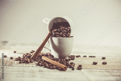 Aromatic coffee seeds and a cup of coffee on a wooden table photo