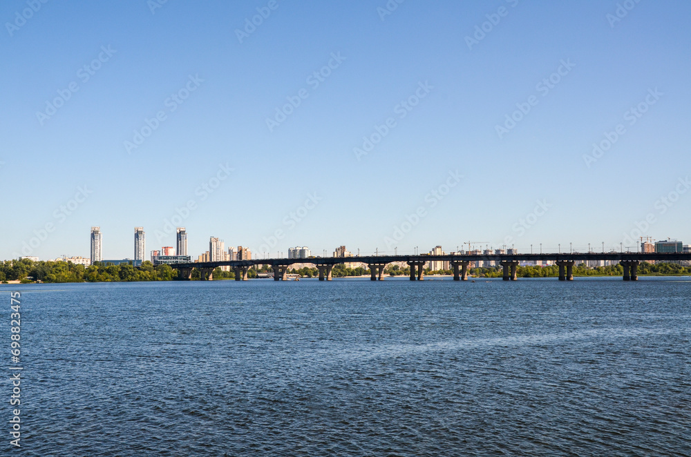 View to Paton Bridge across the Dnipro River and left bank with residential buildings in Kyiv, Ukraine View to Paton Bridge across the Dnipro River and left bank with residential buildings in Kyiv, Ukraine