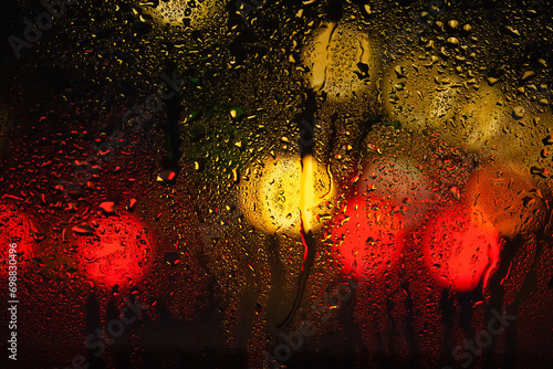 Drops of rain on the window. Drops of water on the glass. Abstract background. Street lights. Texture of drops