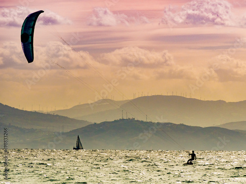 Kite surfer riding waves. Kiteboarding sport.