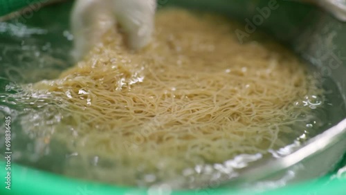 삶은 냉면 국수를 찬물에 행구고 돌돌 말아서 냉면 그릇에 올리고 육수룰 부어서 냉면을 완성하는 