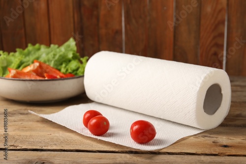 Fresh vegetables and roll of paper towels on wooden table