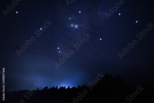 Beautiful starry sky over dark misty forest at night