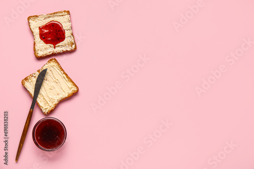 Tasty toasts with butter and jam on pink background photo