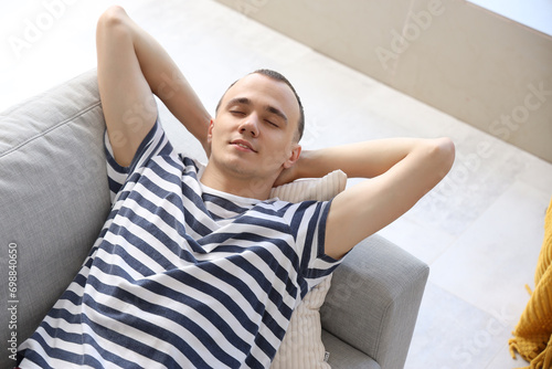 Young man lying on sofa at ...