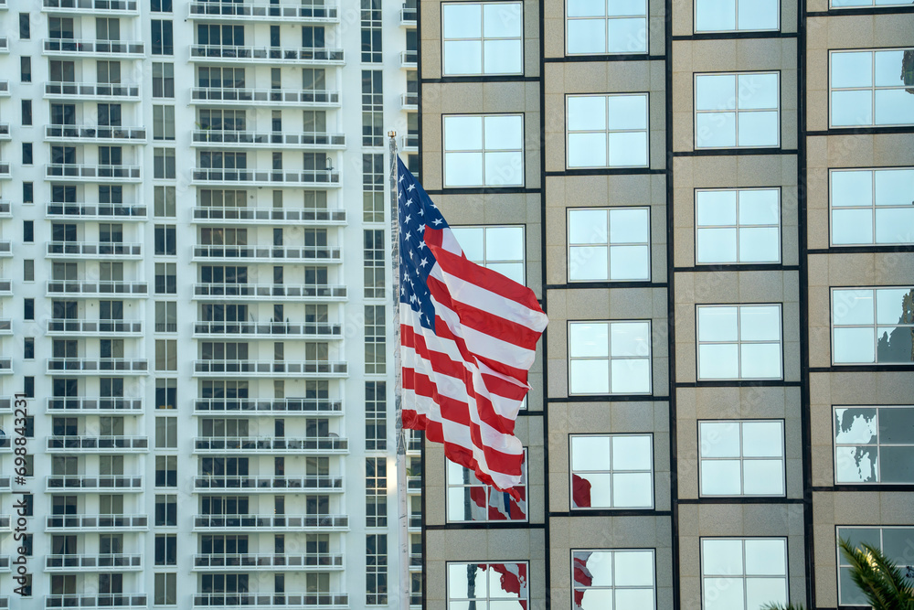 American flag waving in front of Miami skyline. Aerial view of USA stars and stripes spangled banner as symbol of democracy