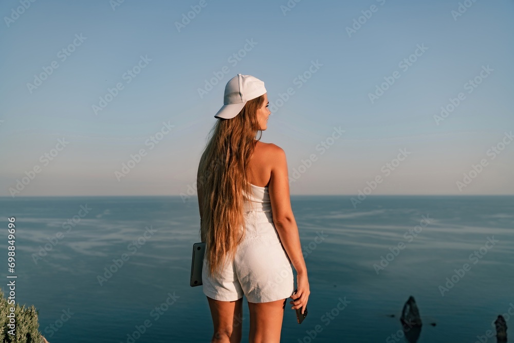 Portrait of a happy woman in a cap with long hair against the sea