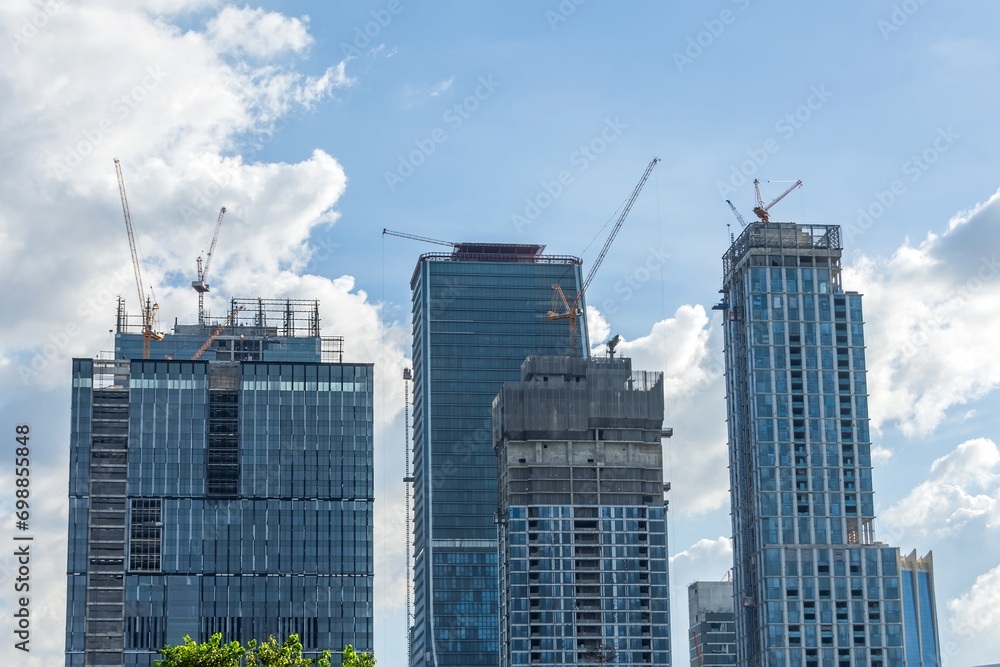 Construction site skyscrapers cranes in cityscape.