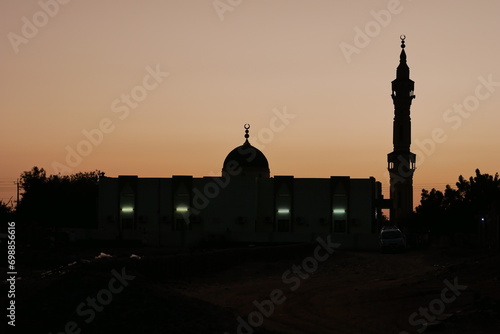 Silhouette of Islamic mosque illuminated against the dusk in the deserts of Dongola, Sudan photo
