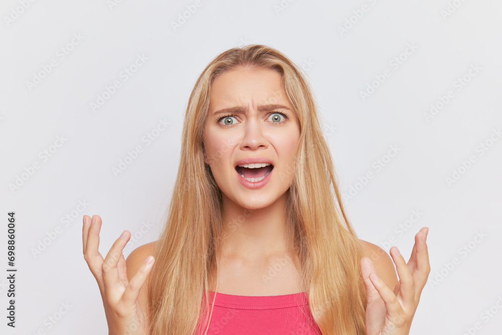 Fair-haired woman with angry expression on face crying angrily over white studio background, hard day concept, copy space Fair-haired woman with angry expression on face crying angrily over white studio background, hard day concept, copy space