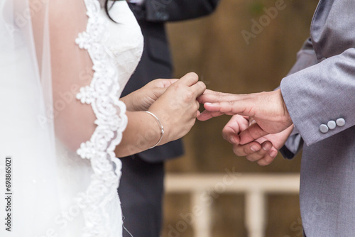 Wedding ceremony of two people holding hand and opening box to show wedding ring