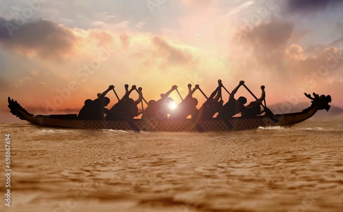 Group of people paddling dragon boat at sunset photo