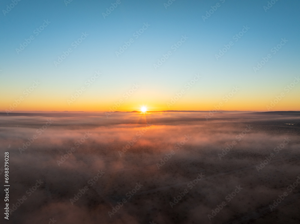Aerial Capture of a Desert’s Blanket, Where Fog and Sunset Dance in Ethereal Harmony