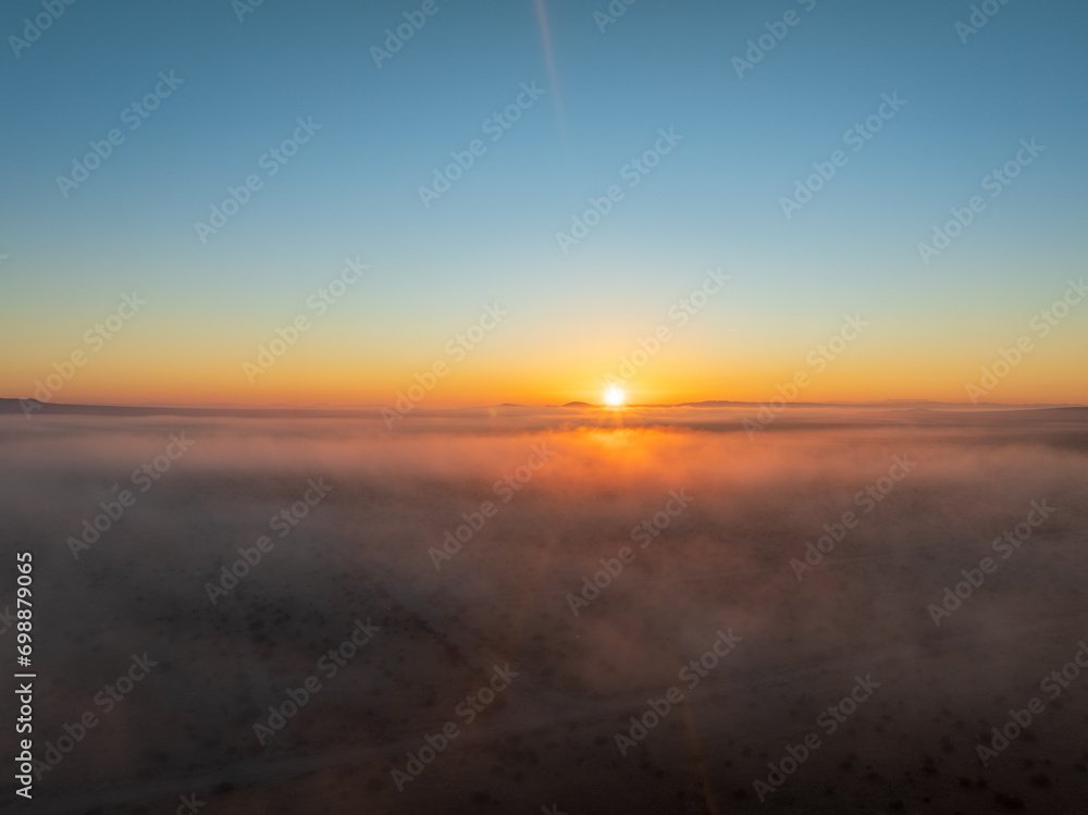 Aerial Elegance with a Blanket of Fog Settled Across the Plains, Embracing the Distant Sunset
