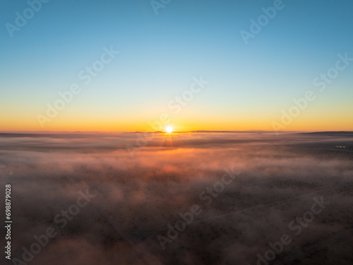 Aerial Capture of a Desert’s Blanket, Where Fog and Sunset Dance in Ethereal Harmony