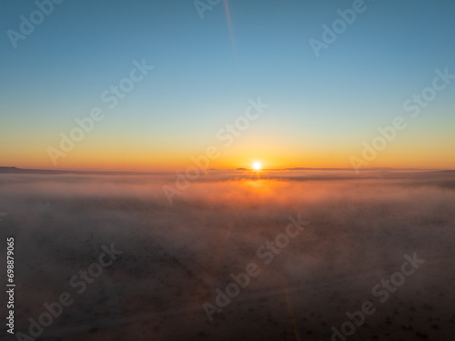 Aerial Elegance with a Blanket of Fog Settled Across the Plains, Embracing the Distant Sunset © FroZone