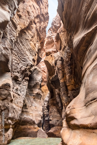 The Mujib  River flows through narrow gorge of Mujib with high mountains along Mujib River Canyon Tourist Route in Wadi Al Mujib in Jordan photo