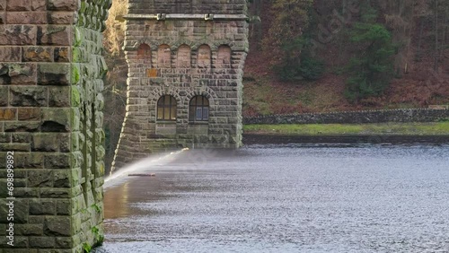 Views of the famous Howden and Derwent stone build Dams, used in the filming of the movie Dam Busters. Showing water overflowing over the dam walls with victorian towers on each side of the structure photo