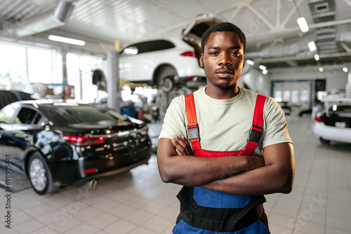 African man mechanic in uniform at the car repair station, portrait