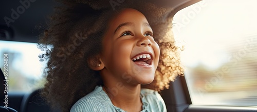 African American daughter in car mirror with cheerful mom on road trip.