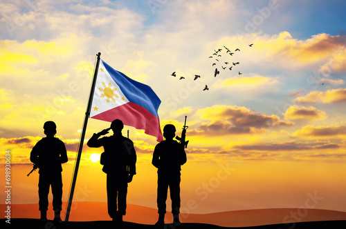 Silhouettes of soldiers with the Philippines flag stand against the background of a sunset or sunrise. Concept of national holidays. Commemoration Day.