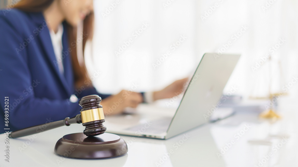 Lawyer woman reading business contract to checking legal agreement with wooden judge gavel on desk - obrazy, fototapety, plakaty 
