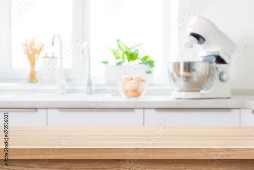 Table top for product display with defocused kitchen sink, electric mixer and eggs as background photo