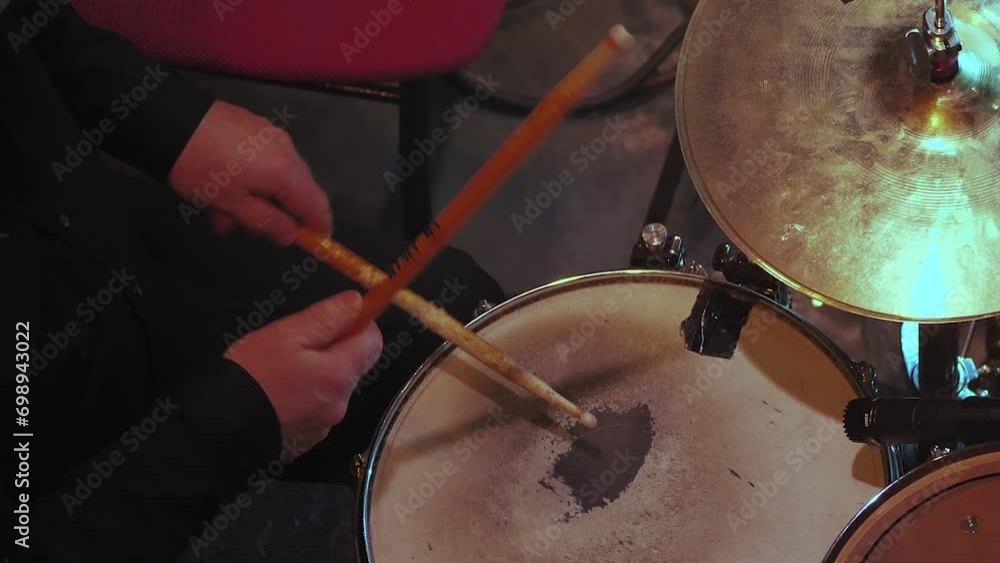 A male drummer playing drums at a rock concert. Close-up. A man playing drums in a close-up view A male drummer playing drums at a rock concert. Close-up. A man playing drums in a close-up view