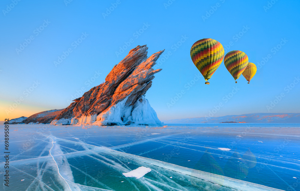 Obraz premium Beautiful winter landscape of frozen Lake Baikal at sunrise - A granite rock with steep slopes rises above a frozen lake - Baikal lake, Siberia