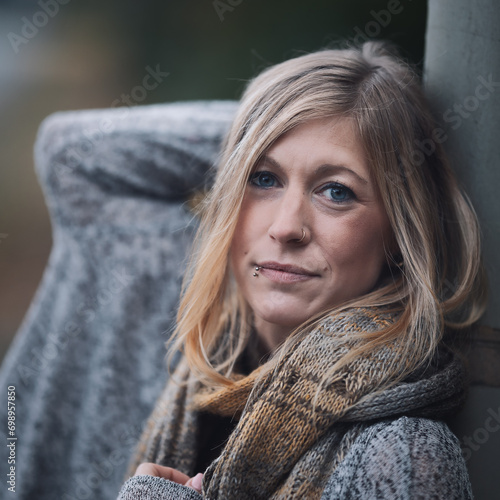 Woman blon head portraits, she is leaning on a lantern pole and puts her right hand behind her head. photo