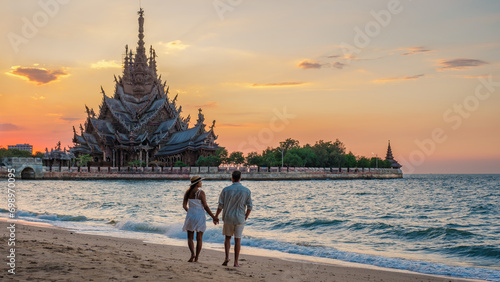 A couple visit The Sanctuary of Truth wooden temple in Pattaya Thailand photo