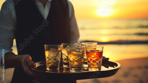 The waiter serves glasses of alcohol on a tray photo