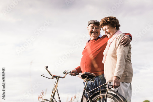 Happy senior couple spending leisure time under cloudy sky photo