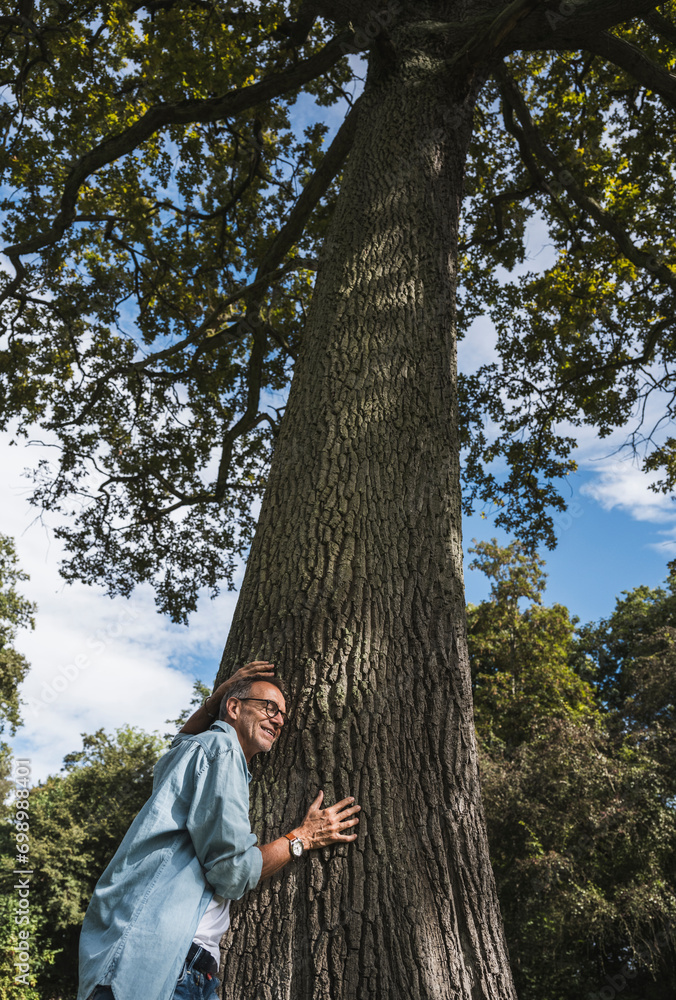 Senior man leaning on tree in park Senior man leaning on tree in park