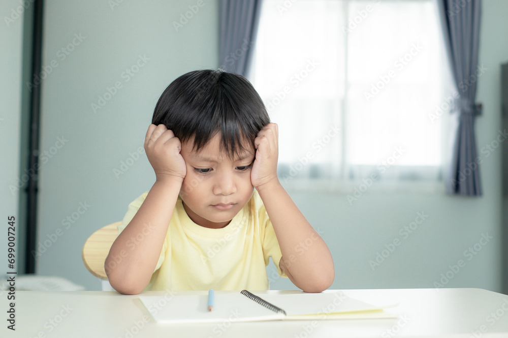 A boy feels bored and tired with his studying and homework A boy feels bored and tired with his studying and homework