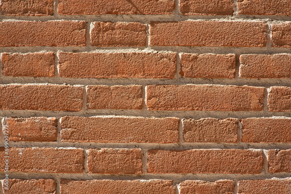 Obraz premium New exposed brick wall without plaster with fired clay bricks and cement mortar suitable for outdoor use