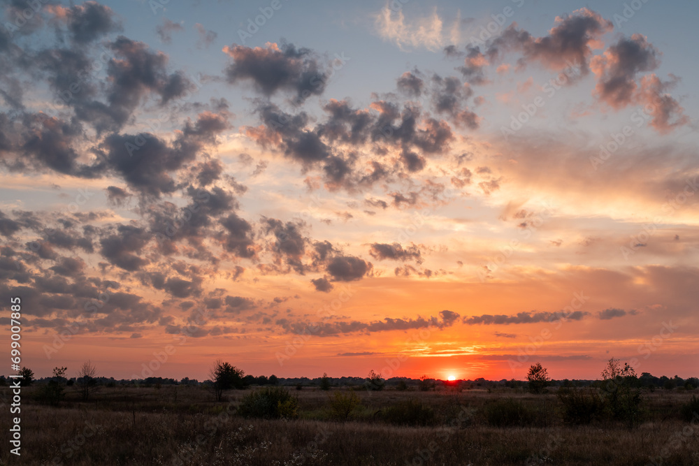 Sunset with beautiful colorful clouds in the sky. Evening in the countryside, bright sky above horizon Sunset with beautiful colorful clouds in the sky. Evening in the countryside, bright sky above horizon