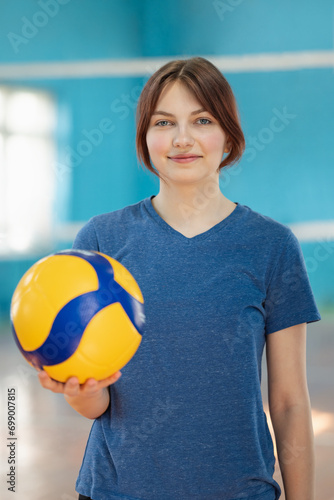 Portrait of a young girl with volleyball ball. Portrait of a sporty female in volleyball court with ball