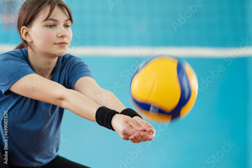 Photo in action of a girl playing volleyball. Young female mastering volleyball skills on volleyball court