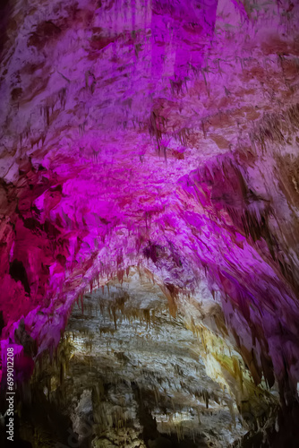 Karst cave, amazing view of stalactites and stalagnites in colorful bright light, beautiful natural landmark in touristic place. photo