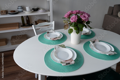 Table setting in the living room. Flowers in a vase on the table. Table decor for the arrival of guests.