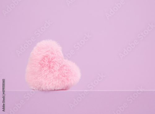 Pink soft plush decorative heart. Copy space for text. Romantic minimalist composition.