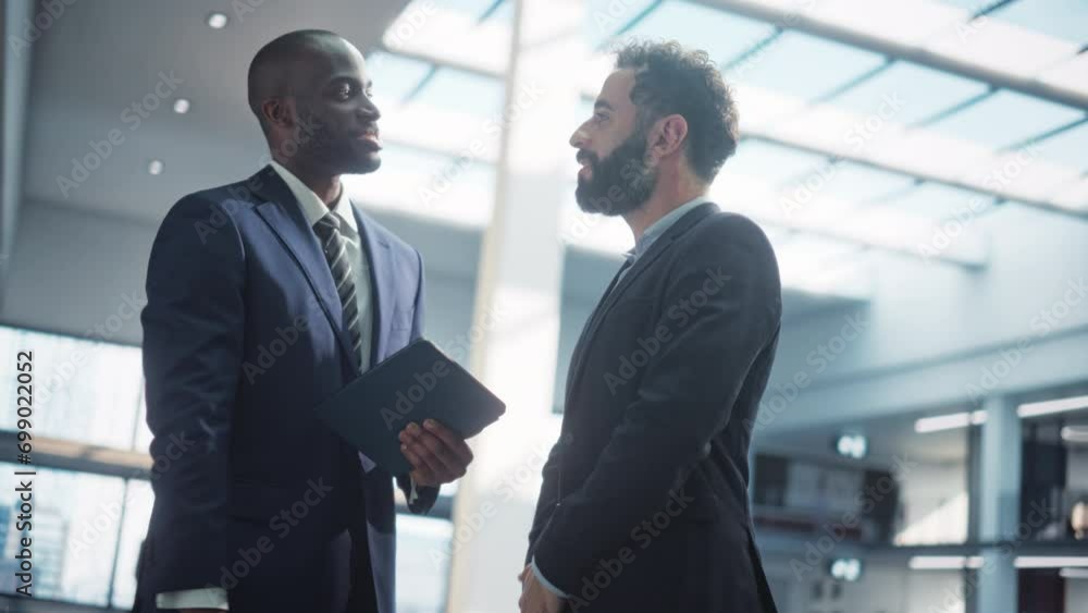 Male Business Partners Meet in Office, Shake Hands. Corporate CEO and Finance Manager Have Meeting in City Office. Businesspeople Came to Discuss Real Estate Purchase and Project. Slow Motion Male Business Partners Meet in Office, Shake Hands. Corporate CEO and Finance Manager Have Meeting in City Office. Businesspeople Came to Discuss Real Estate Purchase and Project. Slow Motion