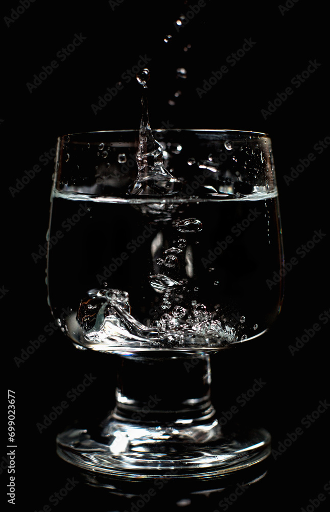 Clean water in a glass on a black background Clean water in a glass on a black background