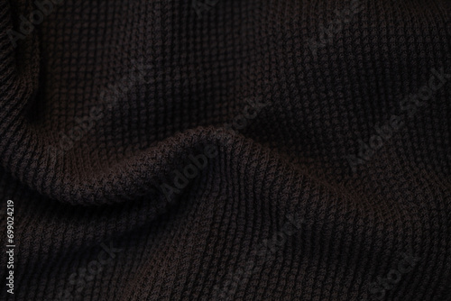 Dark fabric with waves and folds based on PVC. photo