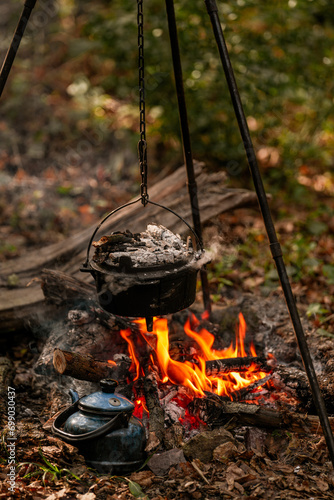 with knife, water bottle and titanium mug near the fire outdoors. bushcraft, adventure, travel, tconcept.ourism and camping
