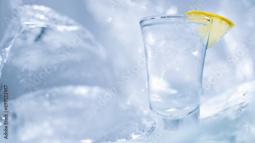 A glass of vodka with ice and lemon